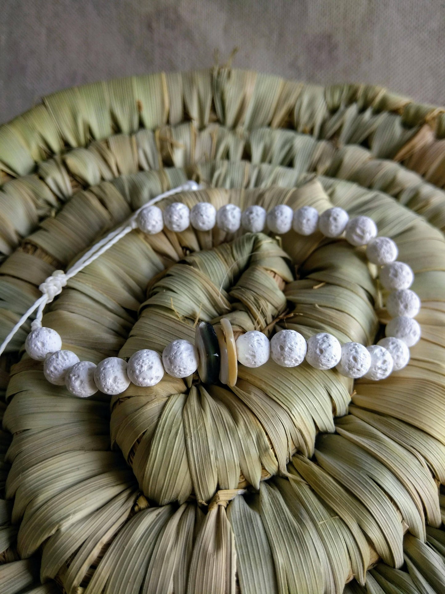 bracciale pietra lavica e conchiglia sfondo cestino