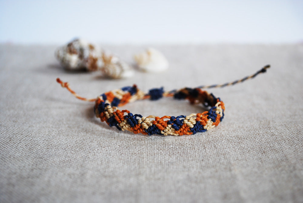 braccialetto intrecci navy terracotta sabbia sfondo conchiglia