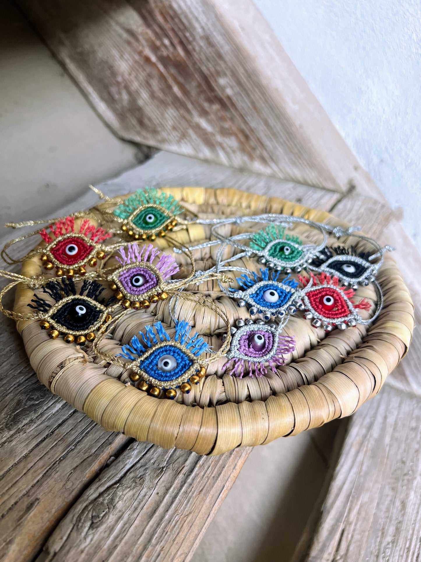 bracciali evil eye tutti i colori su fondo scale legno