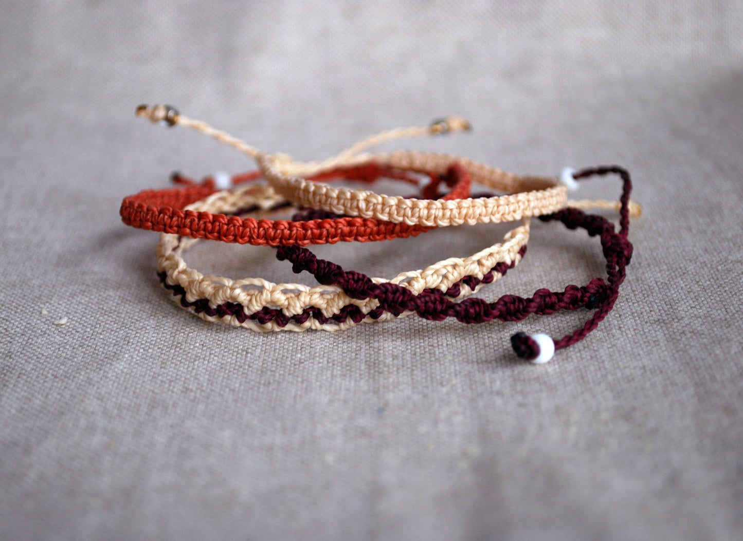Set of four cream and aubergine macramé bracelets