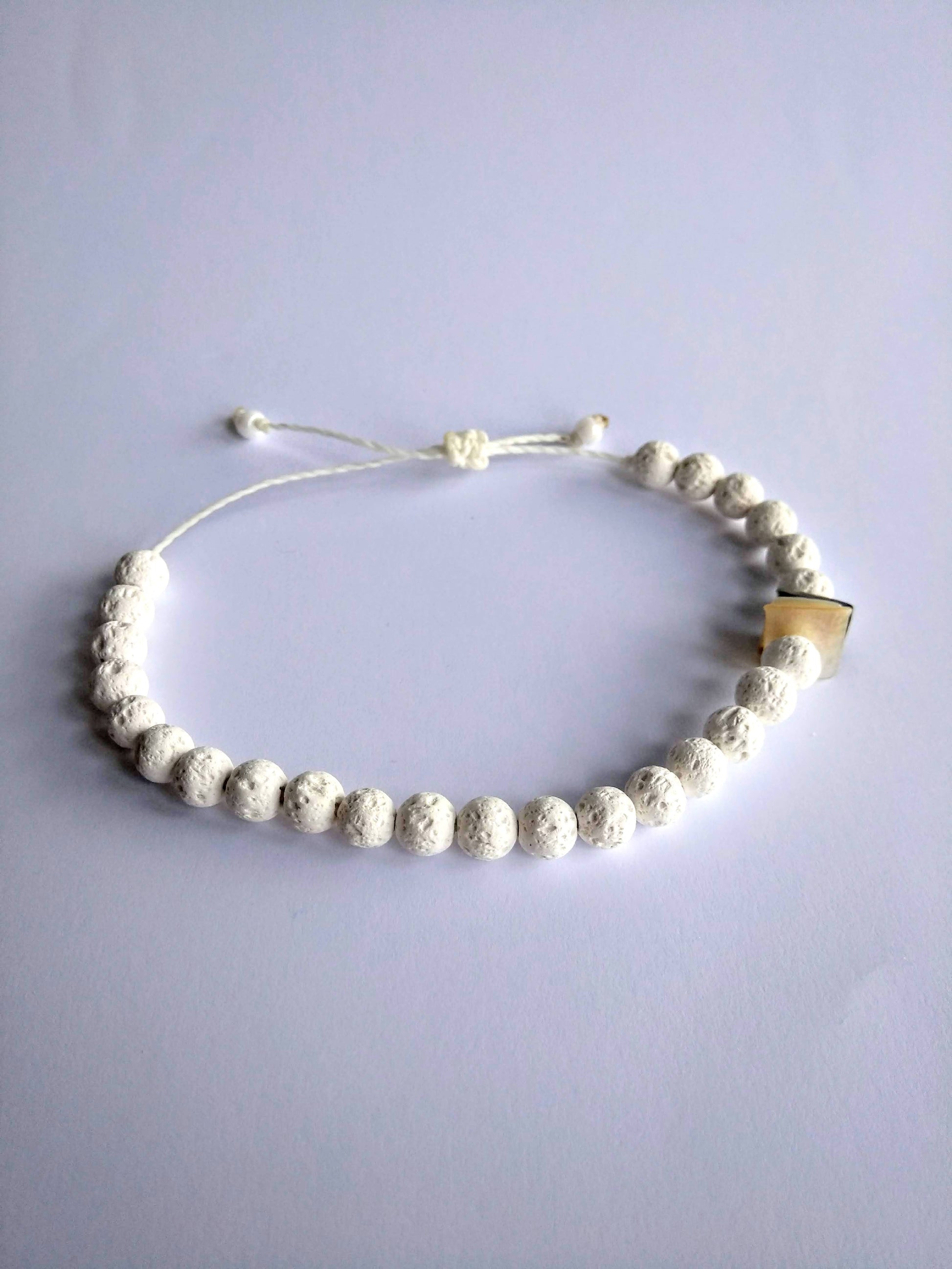 bracciale pietra lavica chips conchiglia sfondo bianco