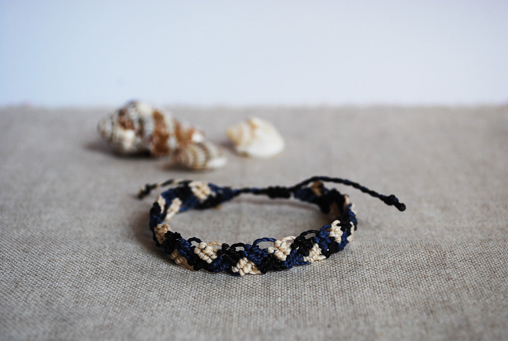 braccialetto intrecci nero panna blu navy sfondo conchiglia