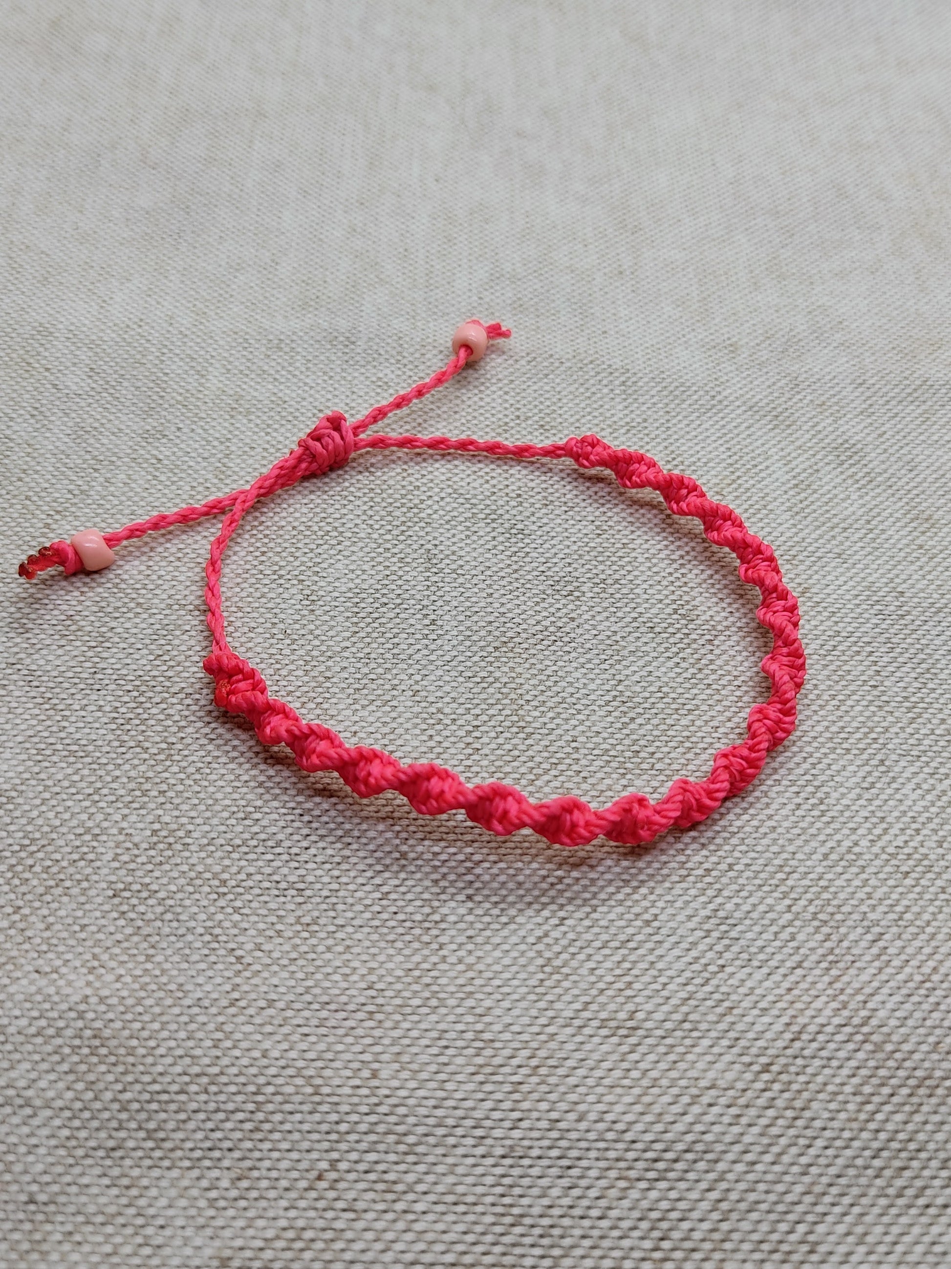 braccialetto rosa fluo twisted sfondo neutro