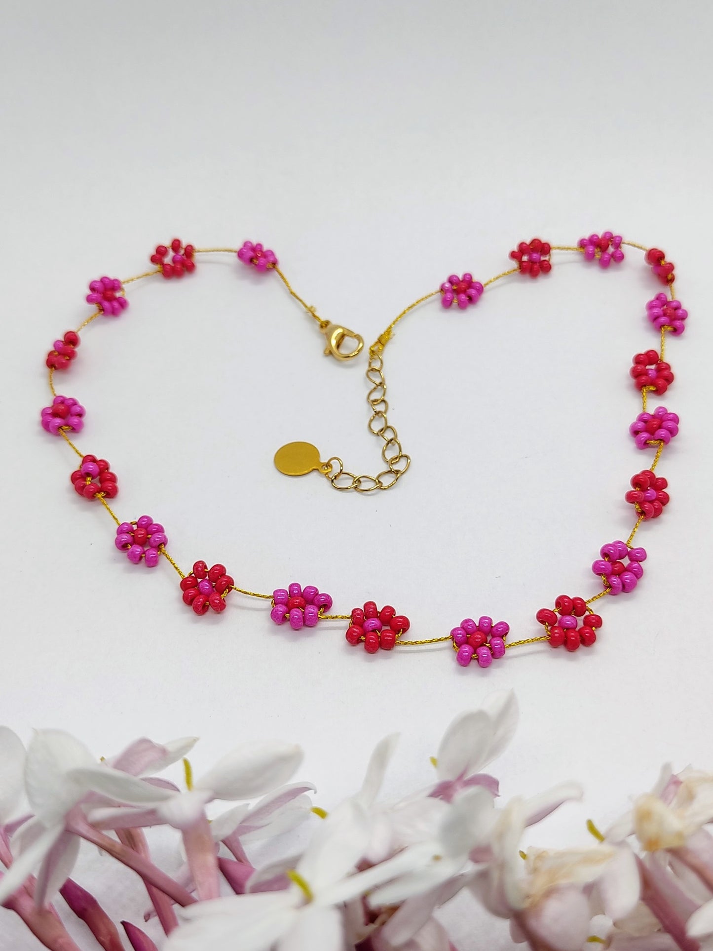 collana fiori rosso fucsia sfondo bianco
