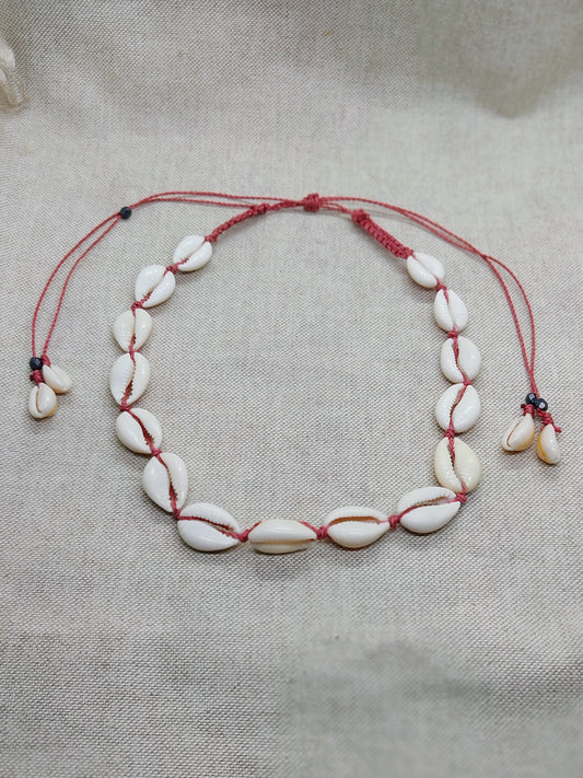 collana conchiglie ciprea rosso magenta sfondo neutro