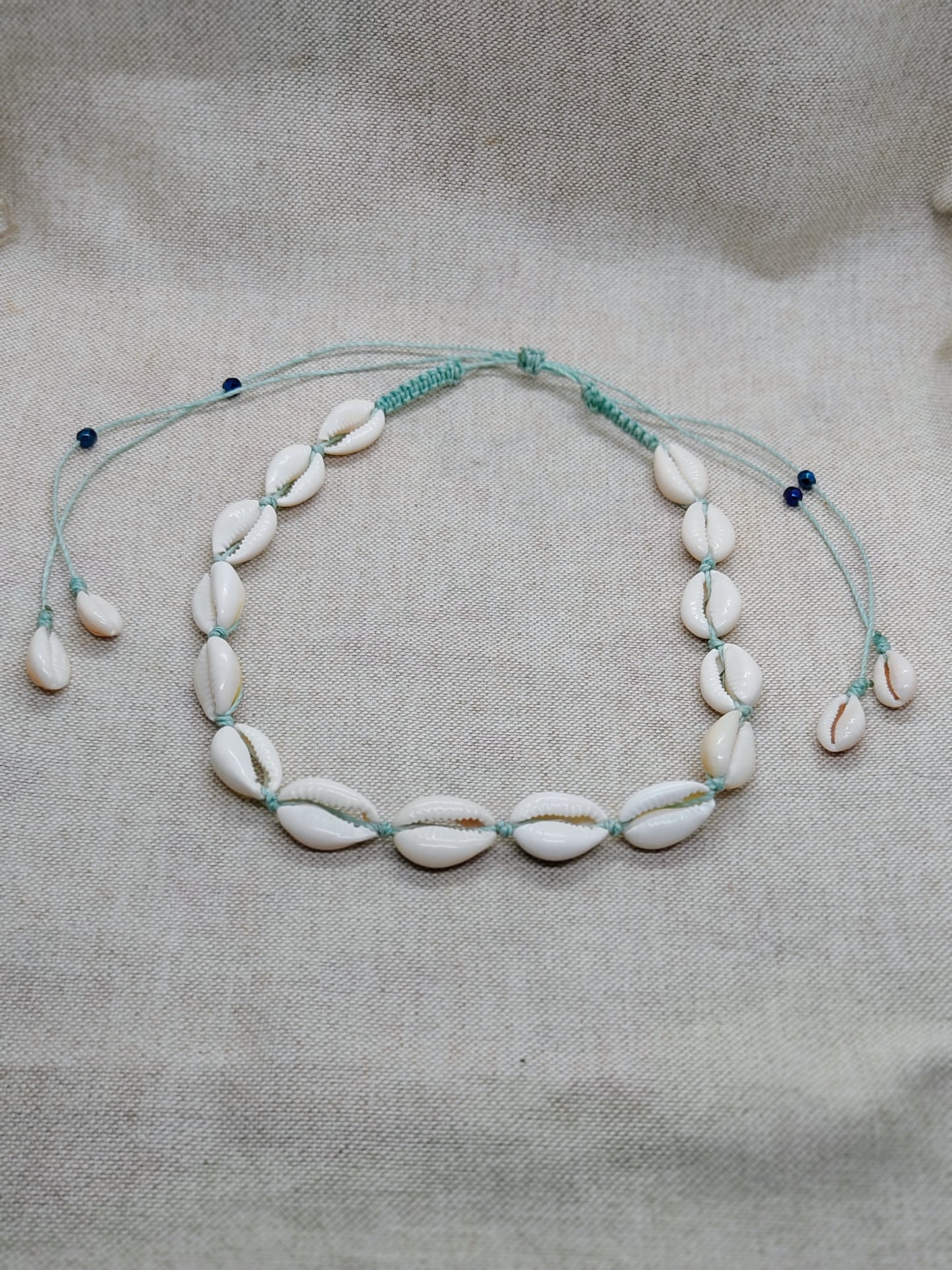 collana conchiglie acqua sfondo beige