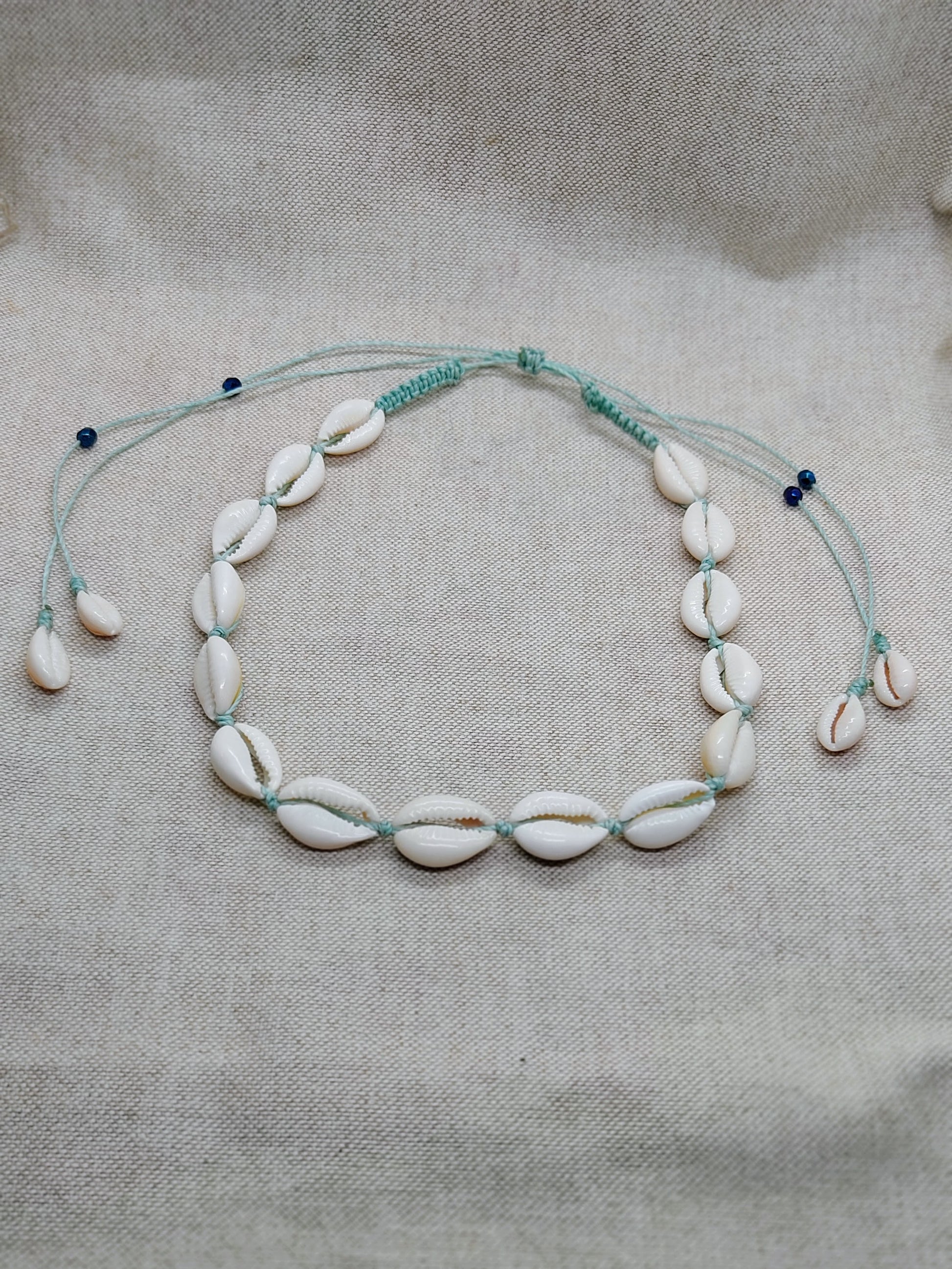 collana conchiglie acqua sfondo beige