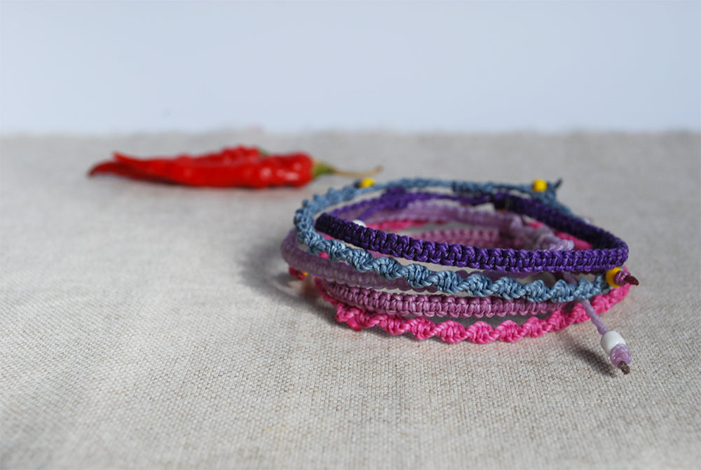 Six of five macrame bracelets in shades of purple