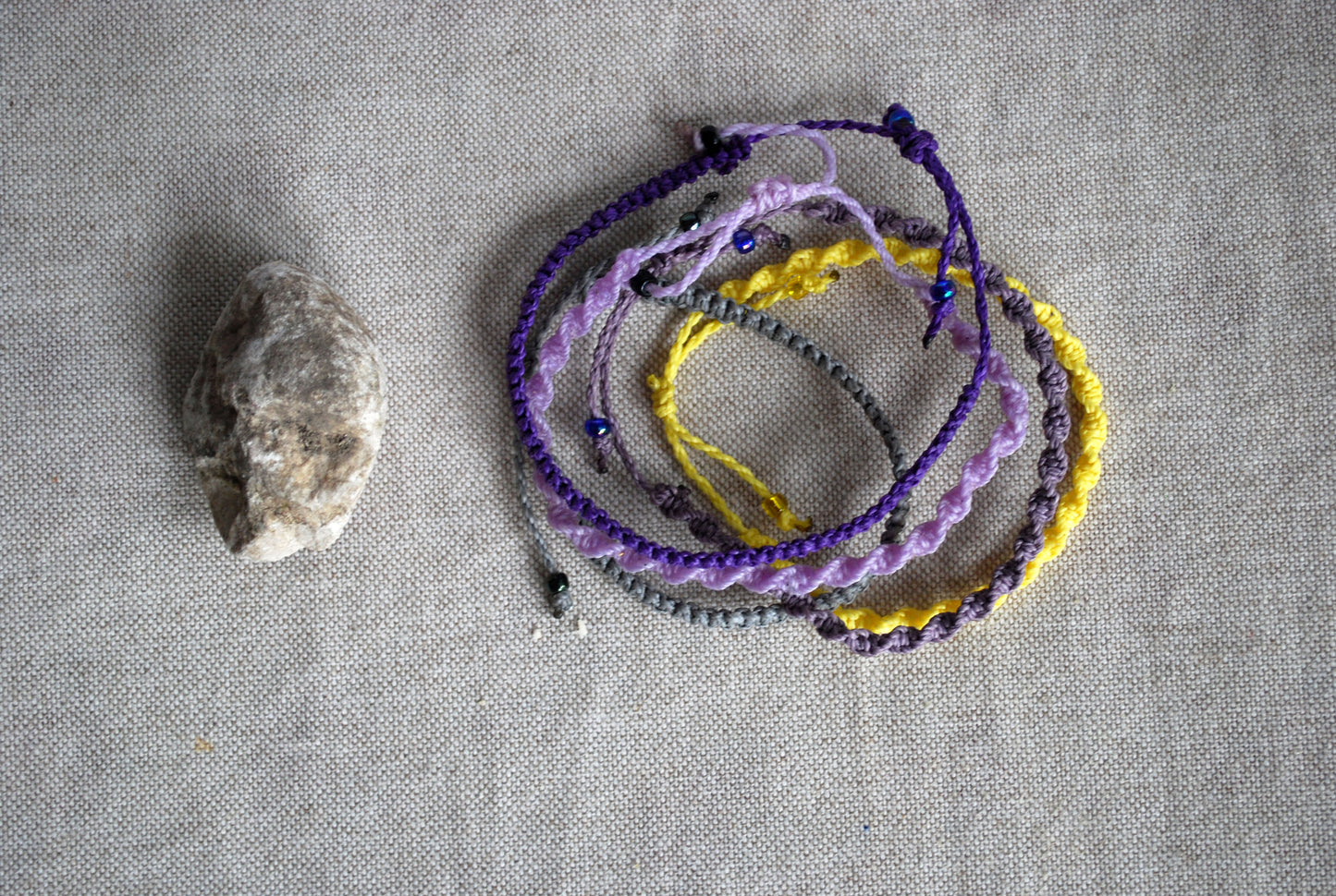 Set di cinque braccialetti a macramè viola e giallo
