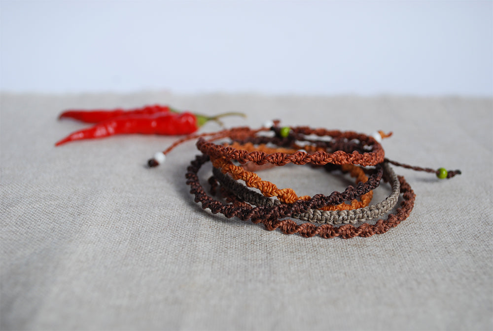 set cinque braccialetti nei toni del marrone sfondo decorato