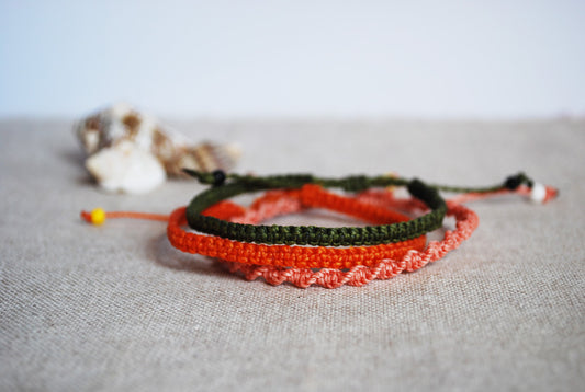 set tre braccialetti pesca arancio verde sfondo conchiglia